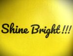A yellow sign that says shine bright